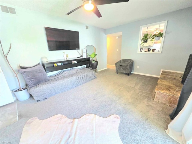 carpeted living room featuring baseboards, a ceiling fan, and visible vents