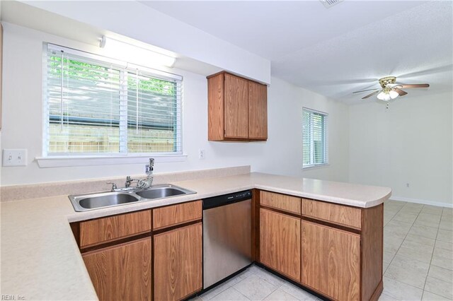 kitchen featuring a sink, light tile patterned floors, dishwasher, light countertops, and a peninsula