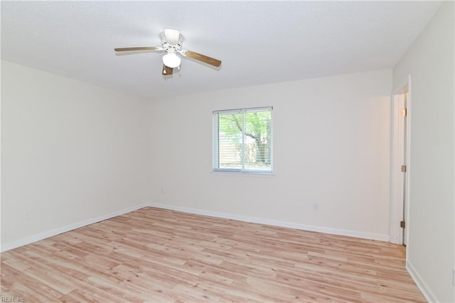 unfurnished room with light wood-style flooring, a ceiling fan, and baseboards