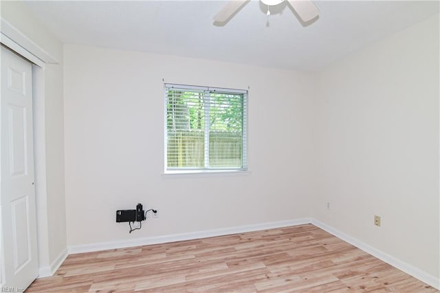 spare room featuring ceiling fan, baseboards, and light wood-style floors