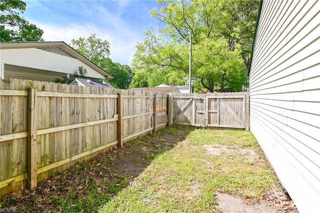 view of yard featuring a gate and a fenced backyard