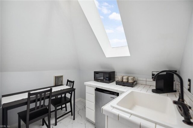 3716 Colonial Ave, Norfolk, VA 23508 - kitchen featuring black microwave, a sink, tile counters, light marble finish floors, and a skylight