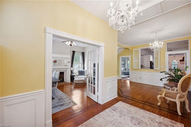 3716 Colonial Ave, Norfolk, VA 23508 - foyer with a wainscoted wall, a chandelier, a decorative wall, dark wood-style floors, and a fireplace