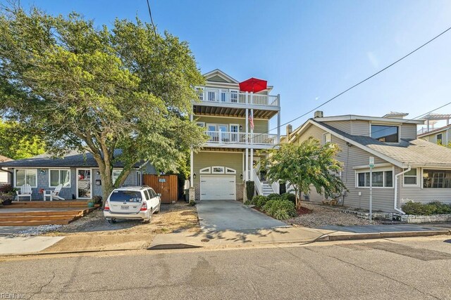 view of front of property featuring an attached garage, driveway, and a balcony
