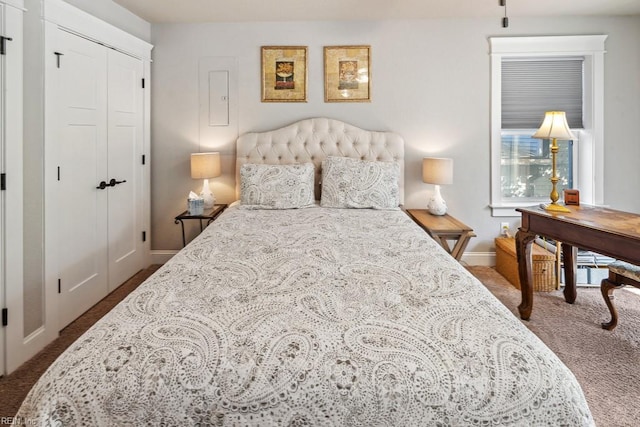 bedroom featuring dark carpet, a closet, and baseboards