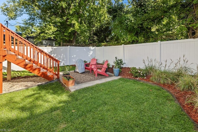 view of yard featuring a fenced backyard, stairway, and a patio