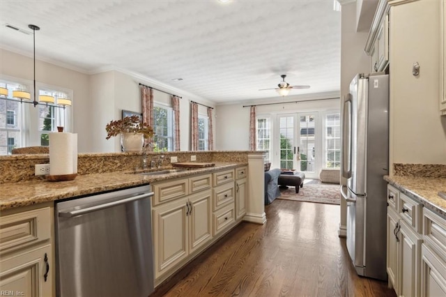 kitchen featuring stainless steel appliances, dark wood-style flooring, ornamental molding, and cream cabinets