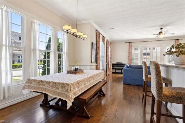 dining room featuring ornamental molding, dark wood-style flooring, and ceiling fan with notable chandelier
