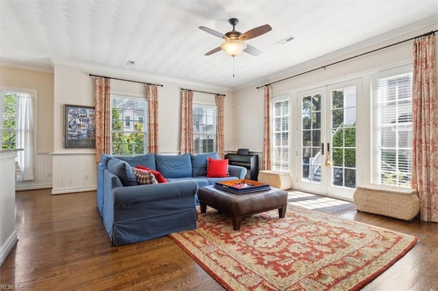 living area featuring crown molding, wood finished floors, a healthy amount of sunlight, french doors, and visible vents