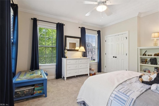carpeted bedroom featuring a closet, a ceiling fan, baseboards, and ornamental molding
