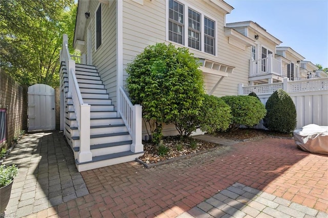 view of home's exterior featuring stairway and fence