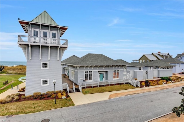 view of front of home featuring board and batten siding, a front lawn, and a balcony