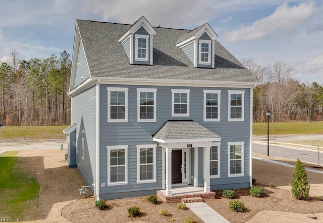 colonial home featuring a shingled roof