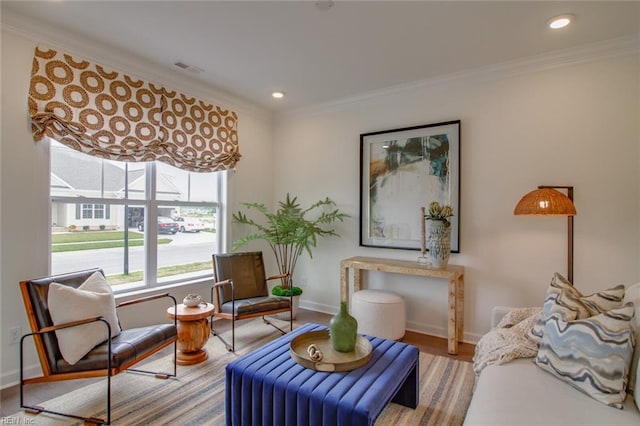 sitting room with wood finished floors, baseboards, ornamental molding, visible vents, and recessed lighting