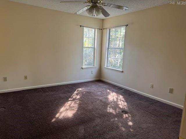 carpeted spare room with baseboards, a ceiling fan, and a textured ceiling
