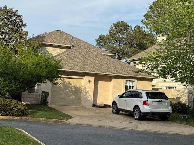 view of front of home featuring driveway, fence, a shingled roof, and a garage