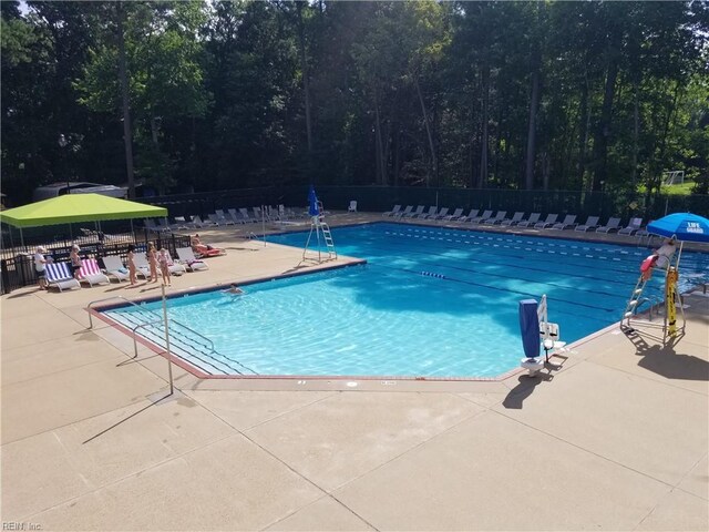 community pool featuring fence and a patio area