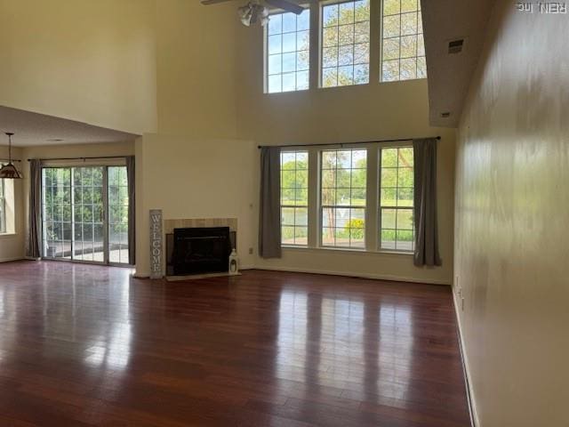 unfurnished living room featuring plenty of natural light, wood finished floors, and ceiling fan