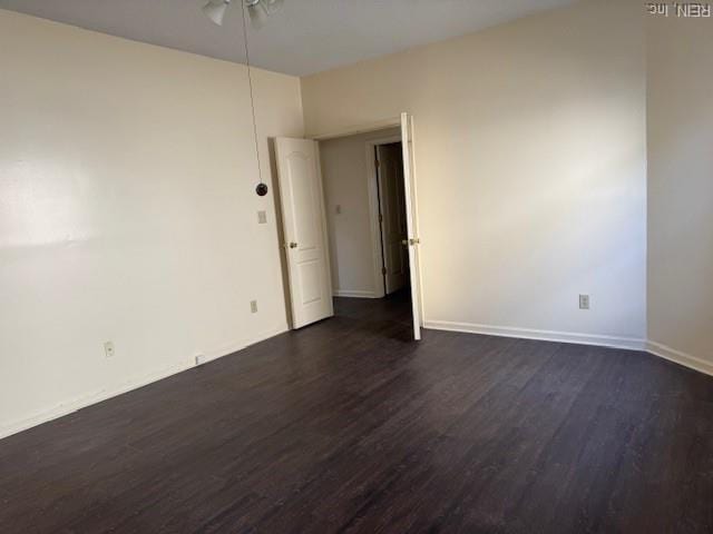 unfurnished room featuring ceiling fan, baseboards, and dark wood-style floors