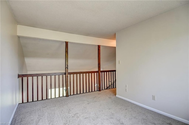 carpeted empty room featuring baseboards and a textured ceiling