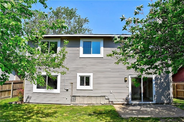 back of house featuring a yard, a patio, and fence