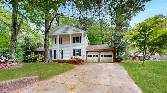 neoclassical home with a garage, driveway, and a front yard