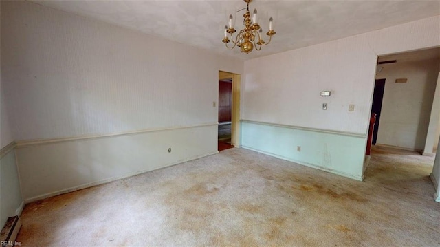 carpeted spare room featuring an inviting chandelier