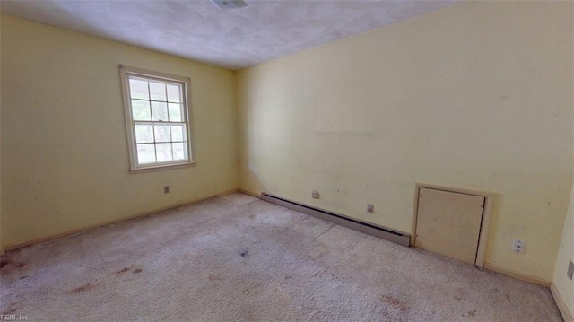 unfurnished room with carpet, baseboards, and baseboard heating