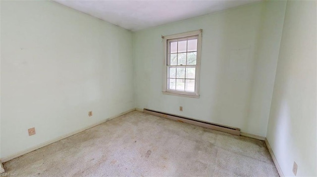 carpeted empty room featuring a baseboard radiator