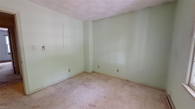 carpeted spare room featuring baseboards, a healthy amount of sunlight, and baseboard heating
