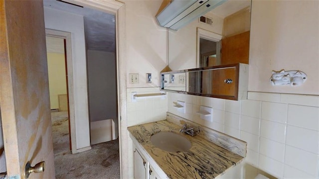 bathroom with vanity, decorative backsplash, and visible vents