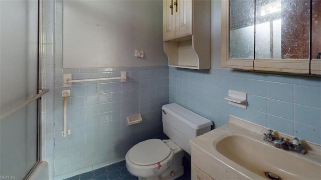 full bath with an enclosed shower, toilet, tile walls, and vanity