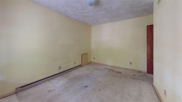 carpeted empty room featuring baseboards and baseboard heating