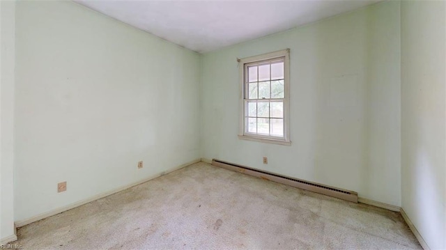 carpeted spare room featuring baseboard heating
