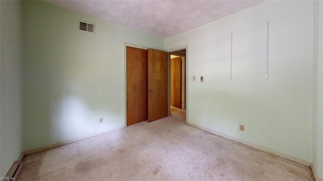 carpeted spare room featuring visible vents