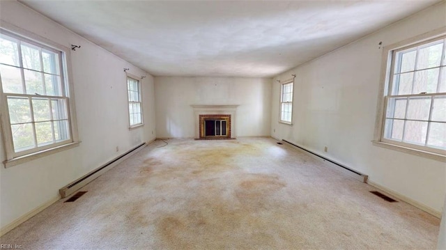 unfurnished living room with visible vents, carpet, and a baseboard heating unit