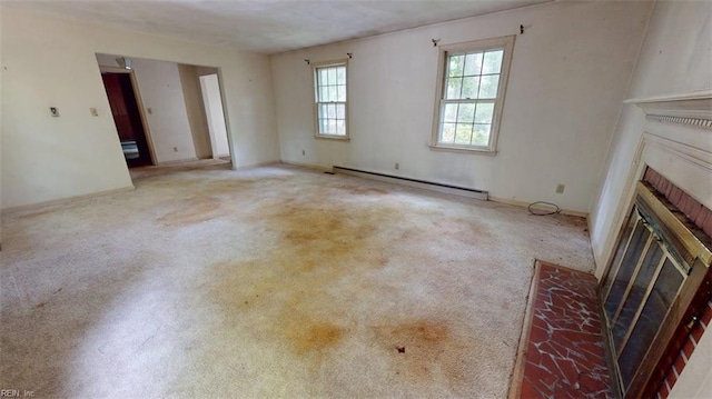 unfurnished living room with carpet, a brick fireplace, and baseboard heating