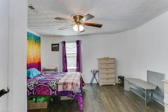 bedroom with a ceiling fan, visible vents, and wood finished floors