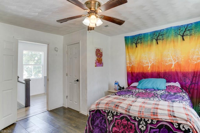 bedroom with wood finished floors, a ceiling fan, and baseboards