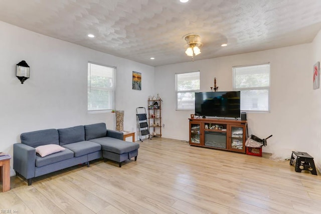 living area featuring light wood-style floors, plenty of natural light, and recessed lighting