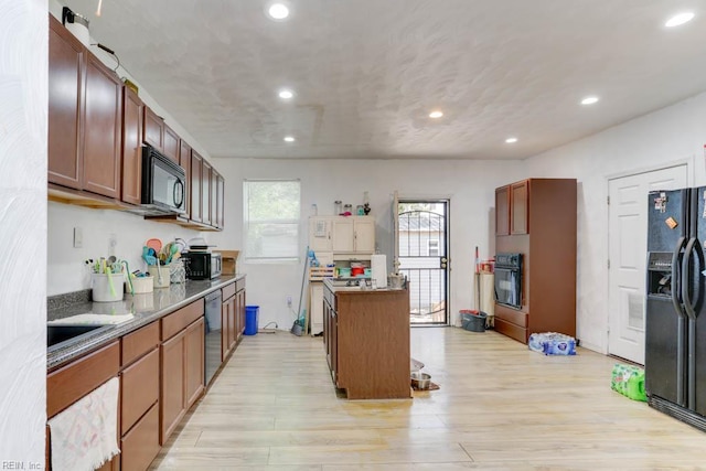 kitchen with a center island, black appliances, light wood-style flooring, and recessed lighting