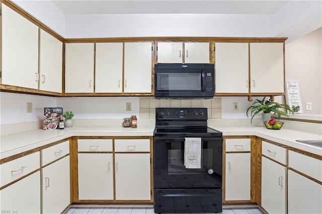 kitchen with black appliances, white cabinetry, and light countertops