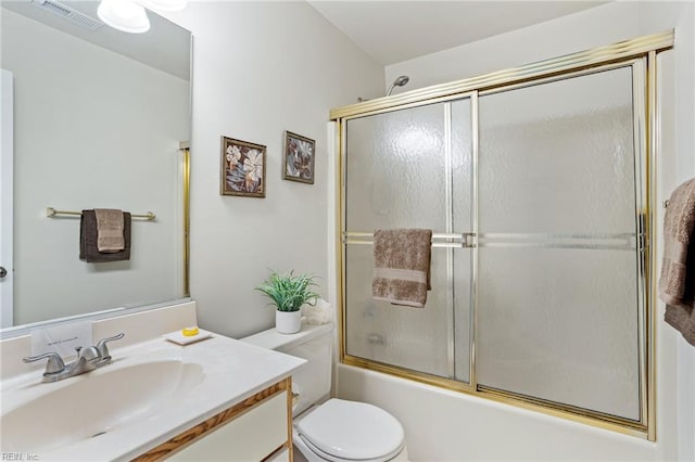 full bathroom featuring visible vents, enclosed tub / shower combo, vanity, and toilet