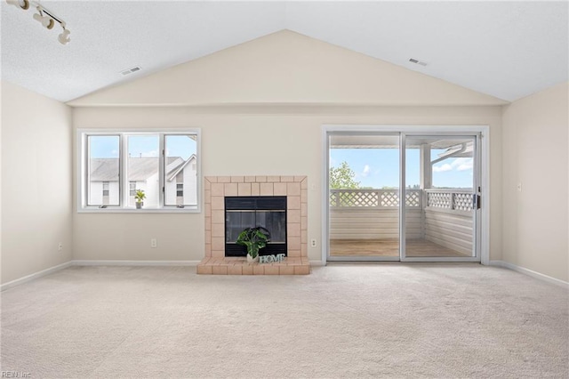unfurnished living room featuring lofted ceiling, a wealth of natural light, and carpet