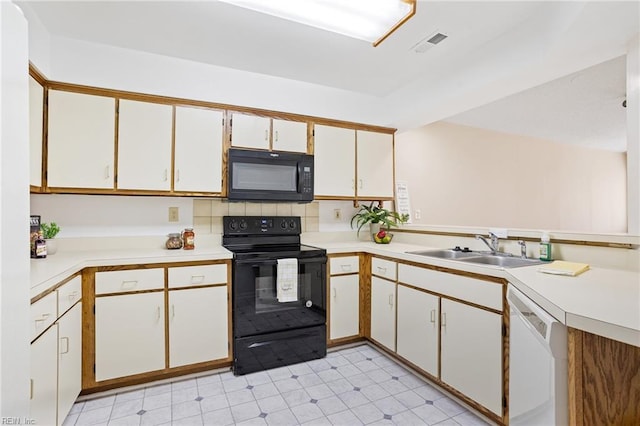 kitchen with white cabinets, light countertops, visible vents, a sink, and black appliances