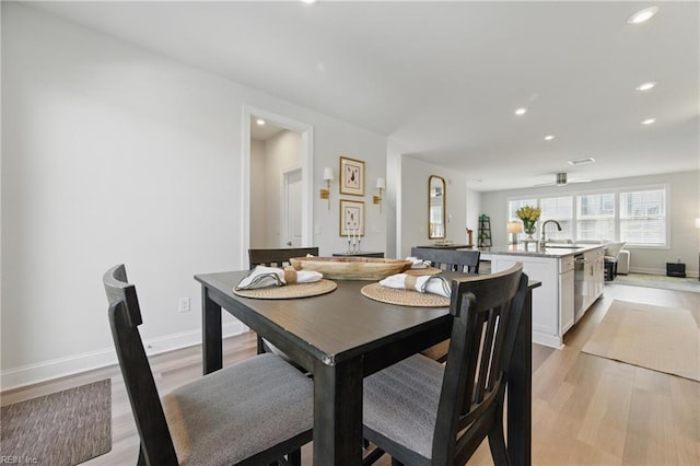 dining room with light wood-type flooring, recessed lighting, and baseboards