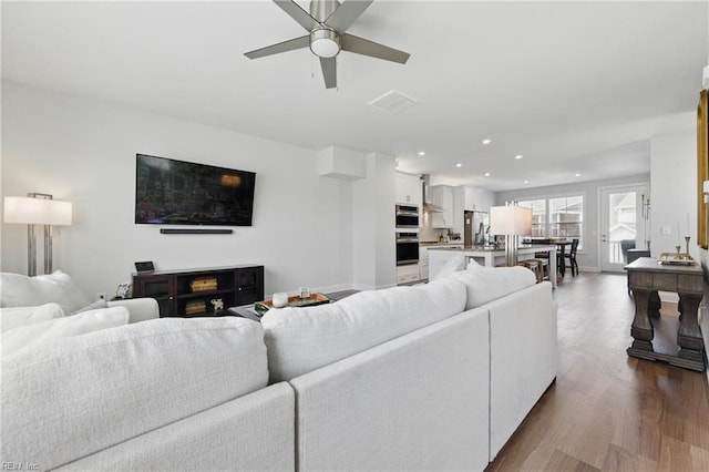 living area featuring dark wood-style flooring, a ceiling fan, recessed lighting, and baseboards