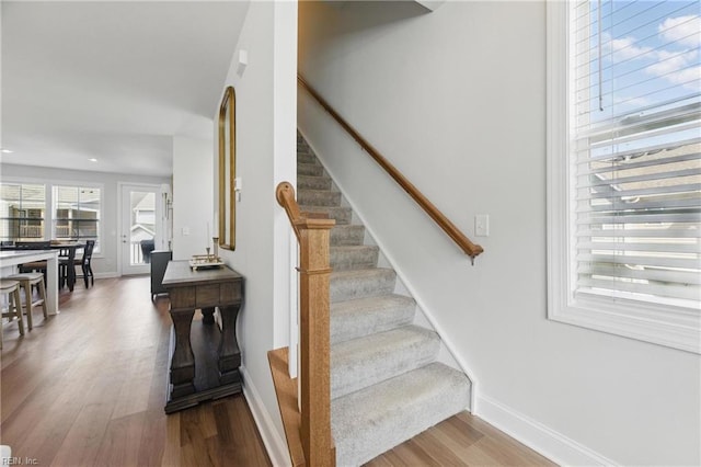 stairs with recessed lighting, wood finished floors, and baseboards