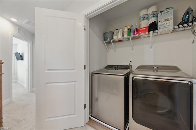 laundry area with washing machine and dryer, visible vents, laundry area, and baseboards