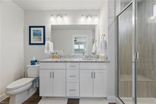 bathroom featuring a stall shower, ceiling fan, toilet, and wood finished floors